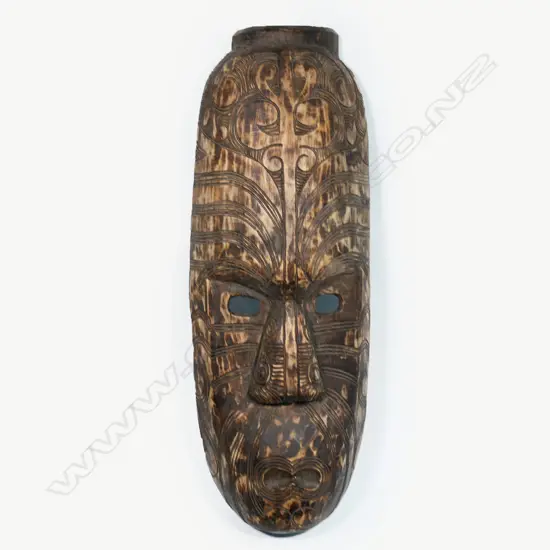 A large carved wooden Māori mask,